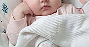 Emilia is registered to the contest to win money with this photo: baby, sleeping, blanket, bed, infant, cozy, soft, peaceful, child, resting, cute, indoors, pajamas, face, head, comfort, warm, pattern, pink, white