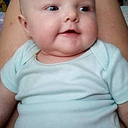 Emilia is registered to the contest to win money with this photo: baby, child, infant, onesie, smiling, face, legs, person, indoor, furniture, home, skin, head, cute, happy, comfort, chubby, relaxed, sitting, closeup