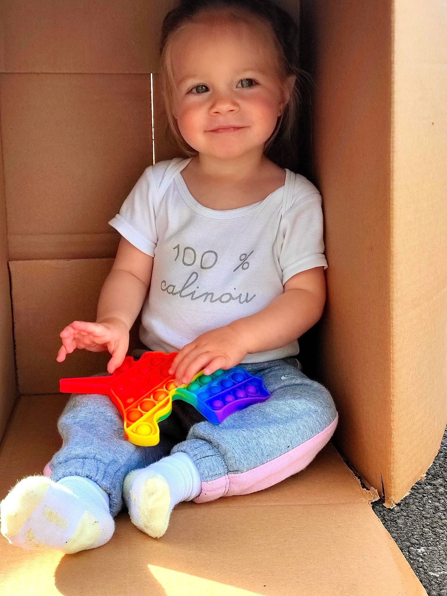 Emy participe au concours pour gagner de l'argent avec cette photo : baby, baby_toddler_clothing, child, electric_blue, face, fun, happy, human_leg, iris, joy, knee, pattern, person, sitting, skin, sleeve, smile, sock, t_shirt, thigh