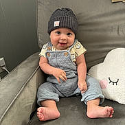 Cole is registered to the contest to win money with this photo: baby, beanie, bodypart, bonnet, cap, chair, clothing, couch, face, finger, furniture, hand, hat, head, jeans, pants, person, photography, portrait, sitting