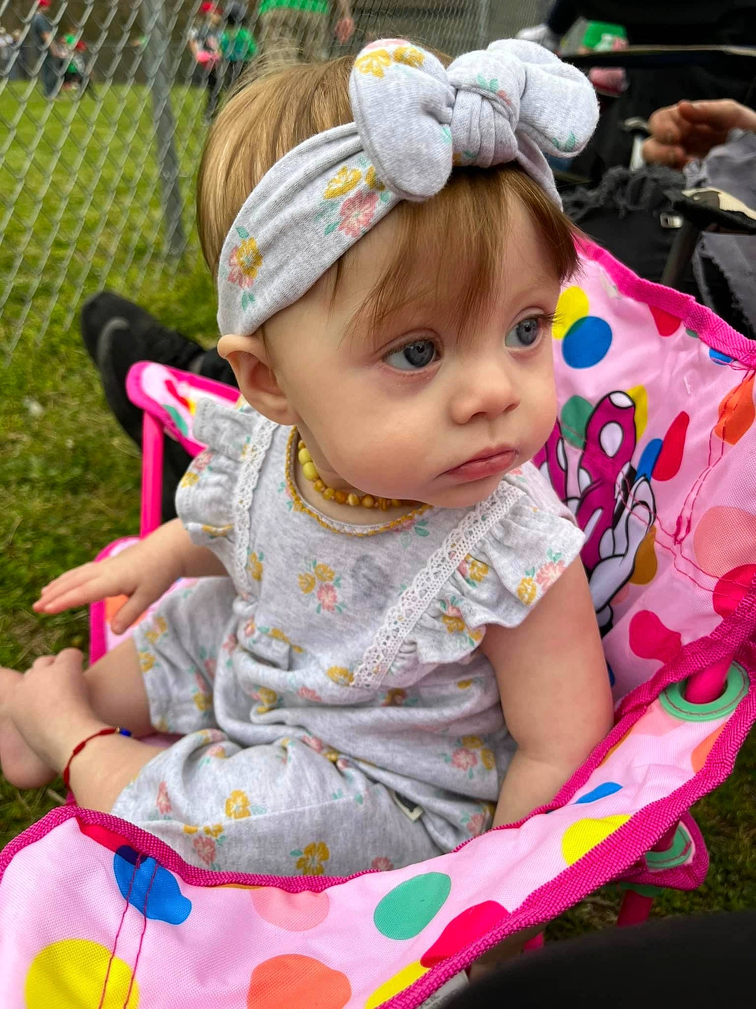 Evyn is registered to the contest to win money with this photo: baby, baby_products, baby_toddler_clothing, child, event, eyelash, fence, fun, grass, green, happy, iris, leisure, magenta, person, pink, recreation, sitting, skin, summer