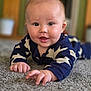 baby, infant, child, carpet, lying_down, blue_clothing, stars_pattern, hand, face, smiling, indoor, soft_texture, cute, young, portrait, skin, eyes, happy, reaching, closeup