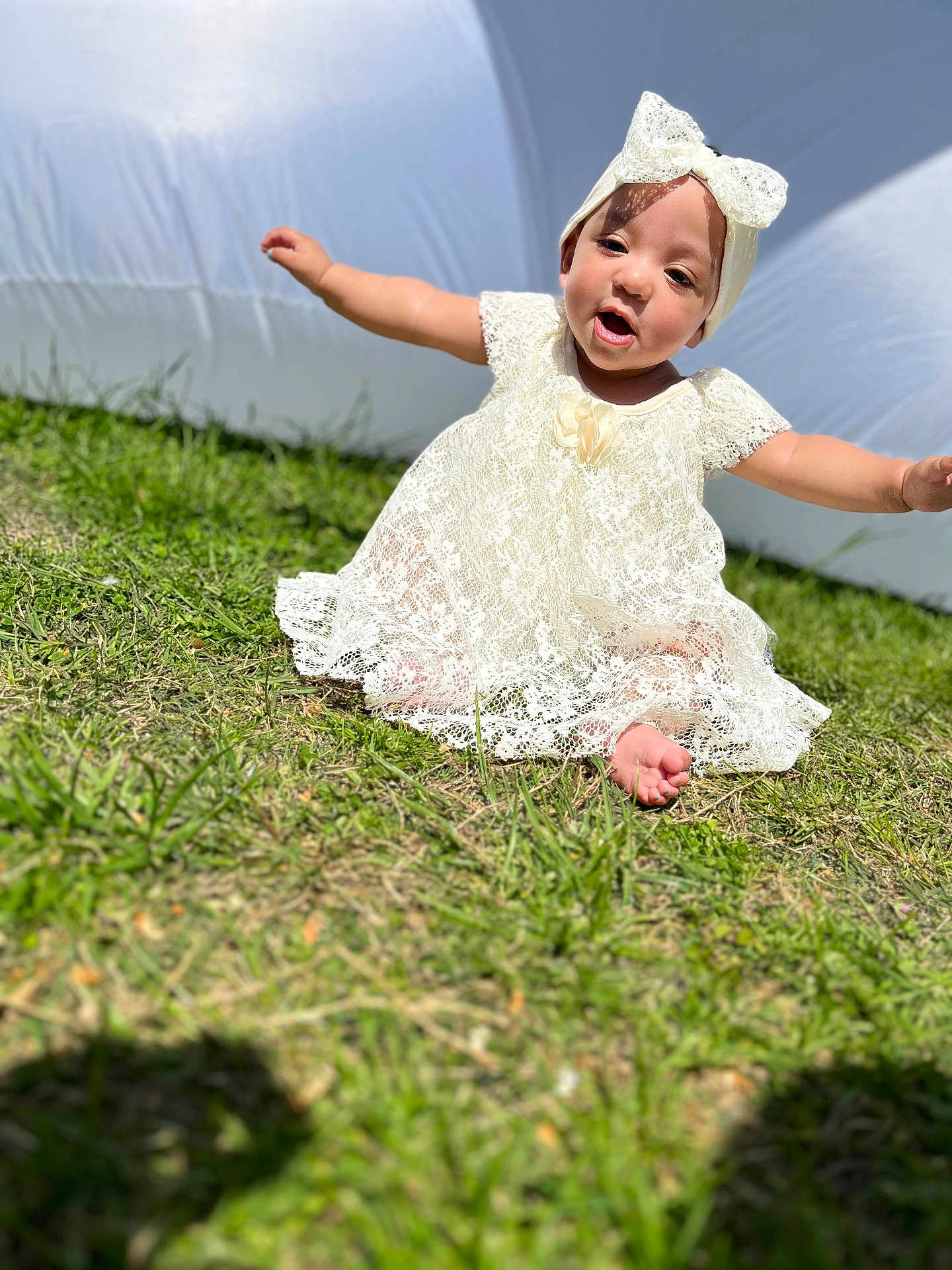 Rahmirah joined the competition — help win amazing prizes! baby, child, grass, outdoor, dress, headband, white, lace, smiling, happy, sitting, sunlight, cute, person, infant, nature, playful, portrait, barefoot, summer