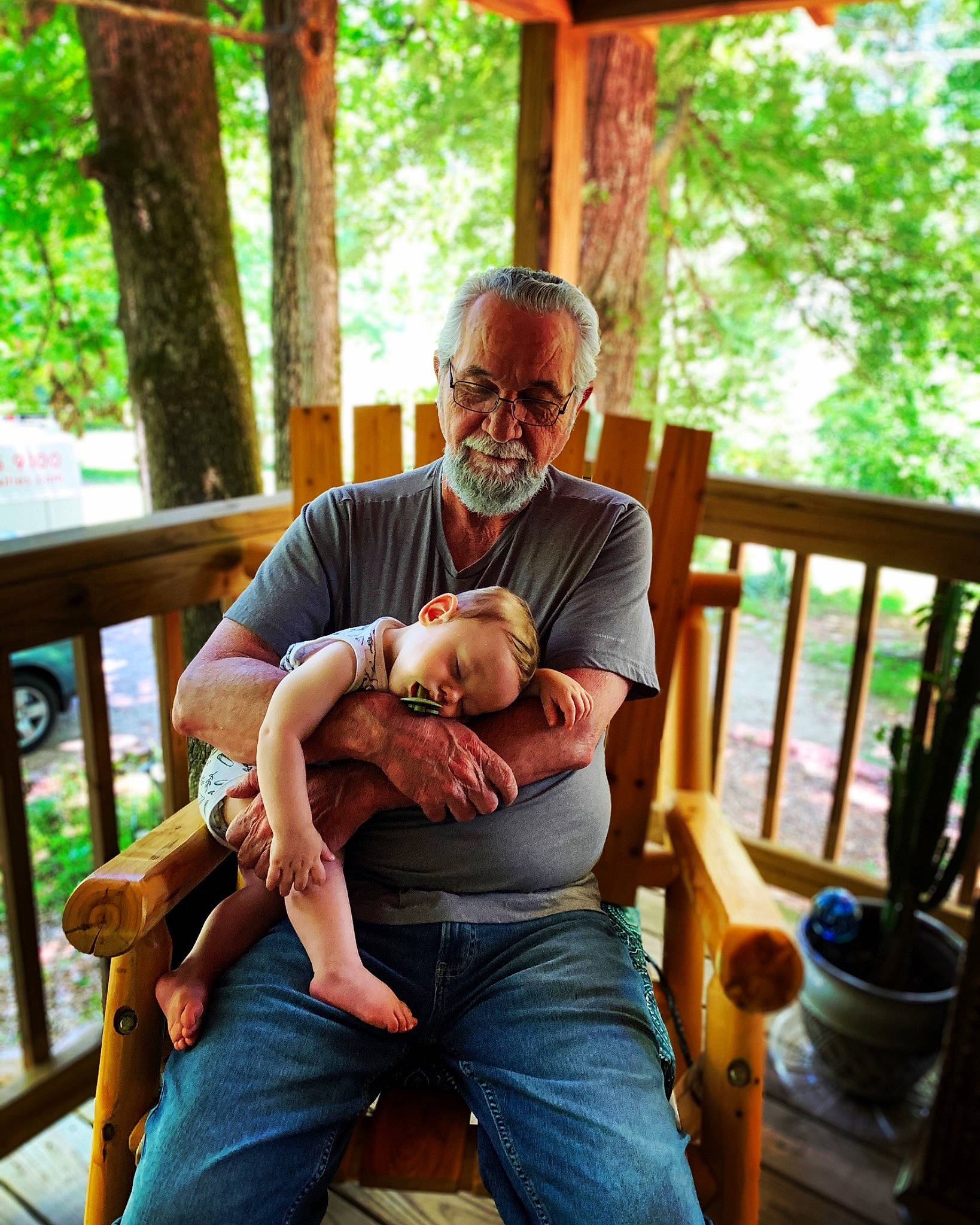 River Ray is registered to the contest to win money with this photo: comfort, event, eyewear, fawn, fun, glasses, grass, green, happy, jeans, lap, leisure, mammal, outdoor_furniture, person, porch, shorts, sunglasses, tableware, tree