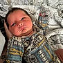 newborn, baby, infant, clothing, onesie, pattern, hand, quilt, blanket, bed, face, person, sleepwear, skin, cute, young, portrait, indoor, resting, comfort