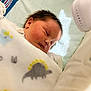 Liam is registered to the contest to win money with this photo: newborn, baby, sleeping, blanket, dinosaur_pattern, crib, soft_lighting, infant, cute, peaceful, face, child, cozy, bed, rest, indoors, portrait, small, wrapped, comfort