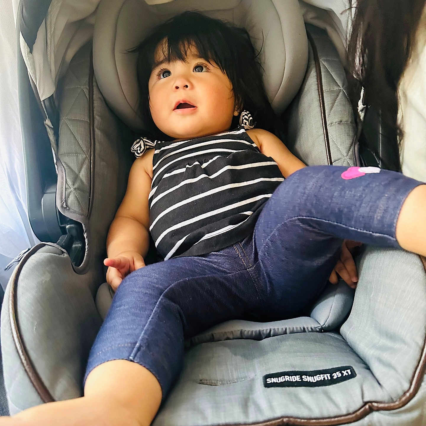 Oriana joined the competition — help win amazing prizes! baby, car_seat, casual, child, childcare, clothing, comfort, cute, denim_leggings, expression, fabric, face, foot, hair, indoor, infant, person, seat, striped_top, toddler