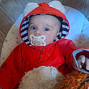 Grace joined the competition — help win amazing prizes! baby, pacifier, hoodie, red_clothing, fuzzy_toy, cushioned_chair, blue_eyes, striped_hood_lining, indoor, cute, child, infant, soft_texture, star_pattern, hand, portrait, closeup, cozy, person, young_child