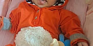 Grace joined the competition — help win amazing prizes! baby, infant, child, onesie, orange_clothing, hood, ears, plush_toy, pink_background, smiling, tongue_out, cute, soft_texture, lying_down, cozy, playful, happy, person, toddler, indoor