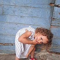 Evangélyne participe au concours pour gagner de l'argent avec cette photo : baby_toddler_clothing, child, elbow, flooring, foot, fun, grass, happy, human_leg, joy, knee, leisure, person, sandal, shorts, sitting, smile, thigh, toddler, wood