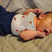 Jackson is registered to the contest to win money with this photo: baby, newborn, blanket, clothing, onesie, hand, face, infant, cute, sleepwear, soft, lying_down, skin, head, small, person, cozy, bedroom, resting, child