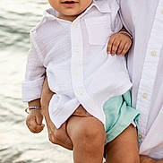 Aarvik is registered to the contest to win money with this photo: toddler, child, baby, person, beach, water, waves, white_shirt, mint_shorts, curly_hair, barefoot, holding, adult, smiling, outdoor, summer, cute, happy, portrait, nature