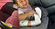Layal is registered to the contest to win money with this photo: baby, car_interior, car_seat, child, clothing, curly_hair, cute, happy, infant, mirror, person, pink_car_seat, playful, portrait, reflection, seatbelt, smiling, sock, toddler, white_sock
