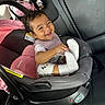 baby, car_interior, car_seat, child, clothing, curly_hair, cute, happy, infant, mirror, person, pink_car_seat, playful, portrait, reflection, seatbelt, smiling, sock, toddler, white_sock