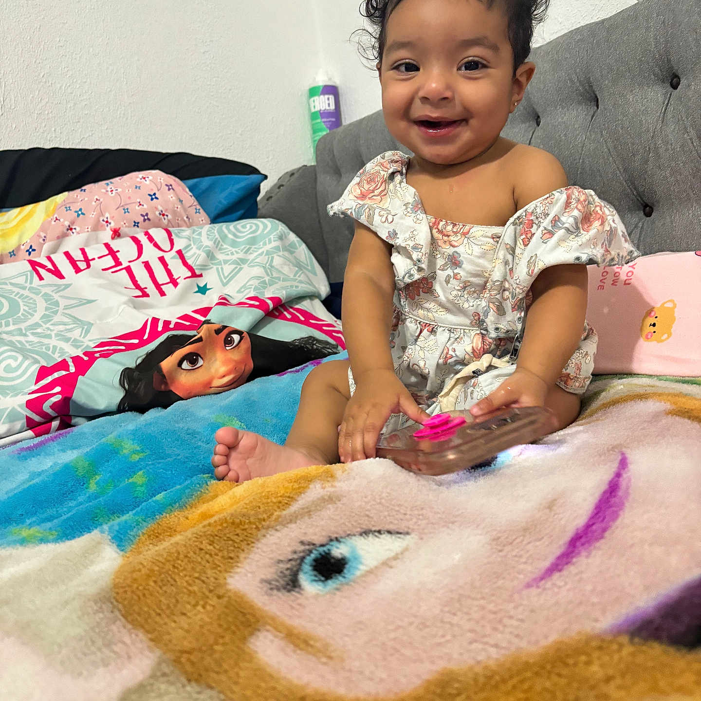 Layal joined the competition — help win amazing prizes! bed, blanket, cartoon_character, child, clothing, colorful, cozy, curly_hair, happy, headboard, indoor, phone, pillow, pop_socket, portrait, room, sitting, smile, toddler, young_child