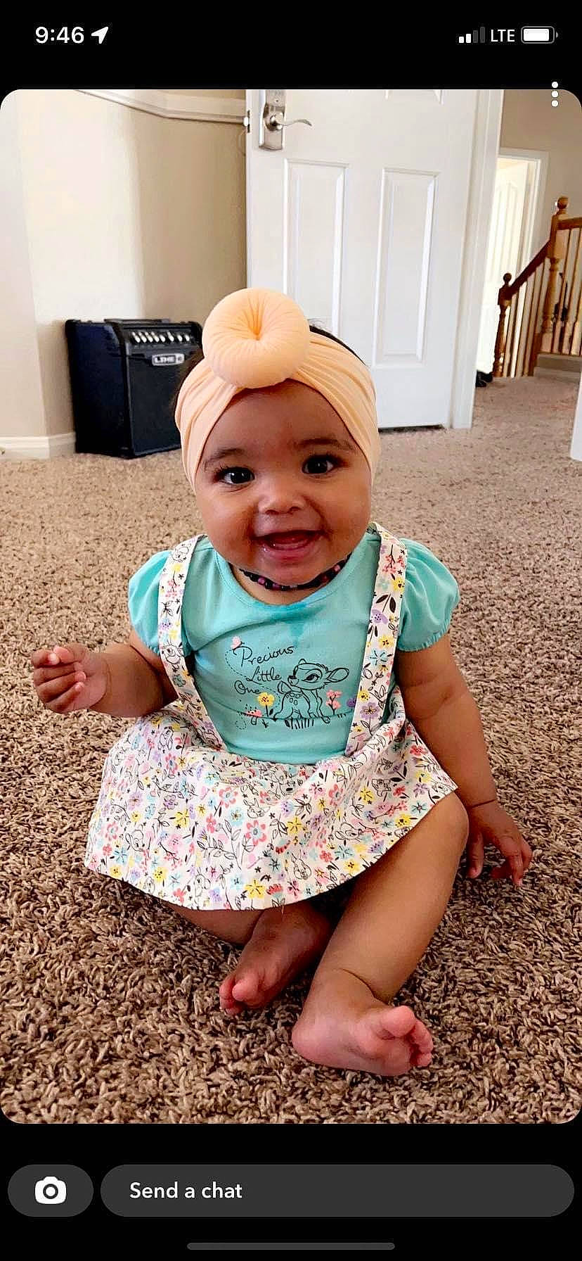 Calliope is registered to the contest to win money with this photo: baby, baby_toddler_clothing, cap, child, eye, face, fashion_accessory, flooring, fun, grass, happy, head, headwear, pattern, person, pink, sitting, skin, sleeve, smile