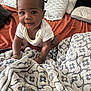 baby, bed, blanket, child, clothing, comfort, crawling, curly_hair, cute, indoors, infant, pattern, person, pillow, portrait, small_hands, smile, soft_texture, white_shirt, young_child