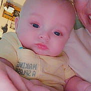 Gunnar is registered to the contest to win money with this photo: baby, infant, person, face, adult, smile, indoor, yellow_shirt, hand, closeup, blue_eyes, skin, head, expression, holding, family, portrait, child, caucasian, room