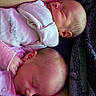 newborn, twins, babies, sleeping, infants, portrait, closeup, pink_clothing, white_clothing, onesies, blanket, cozy, peaceful, faces, heads, eyes_closed, indoors, cuddling, family, soft_lighting