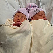 Chargeralan is registered to the contest to win money with this photo: newborn, twins, baby, infant, sleeping, swaddled, hats, pink, white, blanket, hospital, portrait, two_faces, peaceful, cozy, nap, lying_down, matching_outfits, closeup, family