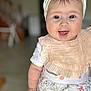 Maïley a rejoint le concours — aidez-le/la à gagner de superbes lots ! baby, child, headband, bow, tongue, smiling, bib, clothing, indoor, person, cute, infant, happy, portrait, standing, floral_pattern, white_shirt, pink, skin, face
