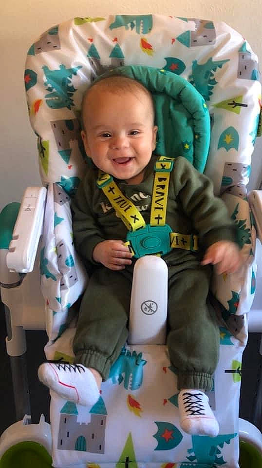 Louie is registered to the contest to win money with this photo: baby, baby_products, baby_toddler_clothing, cheek, child, comfort, eye, face, finger, fun, happy, head, human_body, joy, person, room, sitting, skin, smile, thumb