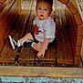 child, colorful, curious, cute, daylight, expression, fun, outdoor, person, play, playground, recreation, shoes, shorts, sitting, toddler, tshirt, wood, wooden_structure, young