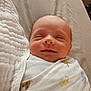 Jace is registered to the contest to win money with this photo: baby, newborn, blanket, smile, face, infant, sleepy, swaddled, cute, child, cozy, soft, animal_print, lying_down, peaceful, indoors, head, skin, portrait, resting