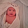 Jaxon is registered to the contest to win money with this photo: baby, bed, blanket, child, comfort, cute, expression, face, head_covering, hooded_towel, indoors, infant, lying_down, person, skin, sleepwear, smile, soft, towel, warm