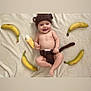 baby, infant, crocheted_hat, crocheted_diaper_cover, monkey_costume, banana, soft_blanket, smiling, cute, playful, toy, lying_down, bare_chest, happy, child, adorable, indoors, portrait, yellow, brown