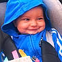 baby, blue_hoodie, car_seat, child, smile, toy, colorful, face, happy, infant, cute, clothing, seatbelt, indoors, closeup, person, playful, young_child, dimple, hood