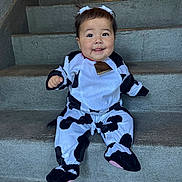 Esmeralda is registered to the contest to win money with this photo: baby, child, costume, cow, stairs, smile, cute, sitting, outdoor, face, happy, clothing, footwear, portrait, infant, playful, headwear, person, young, fun
