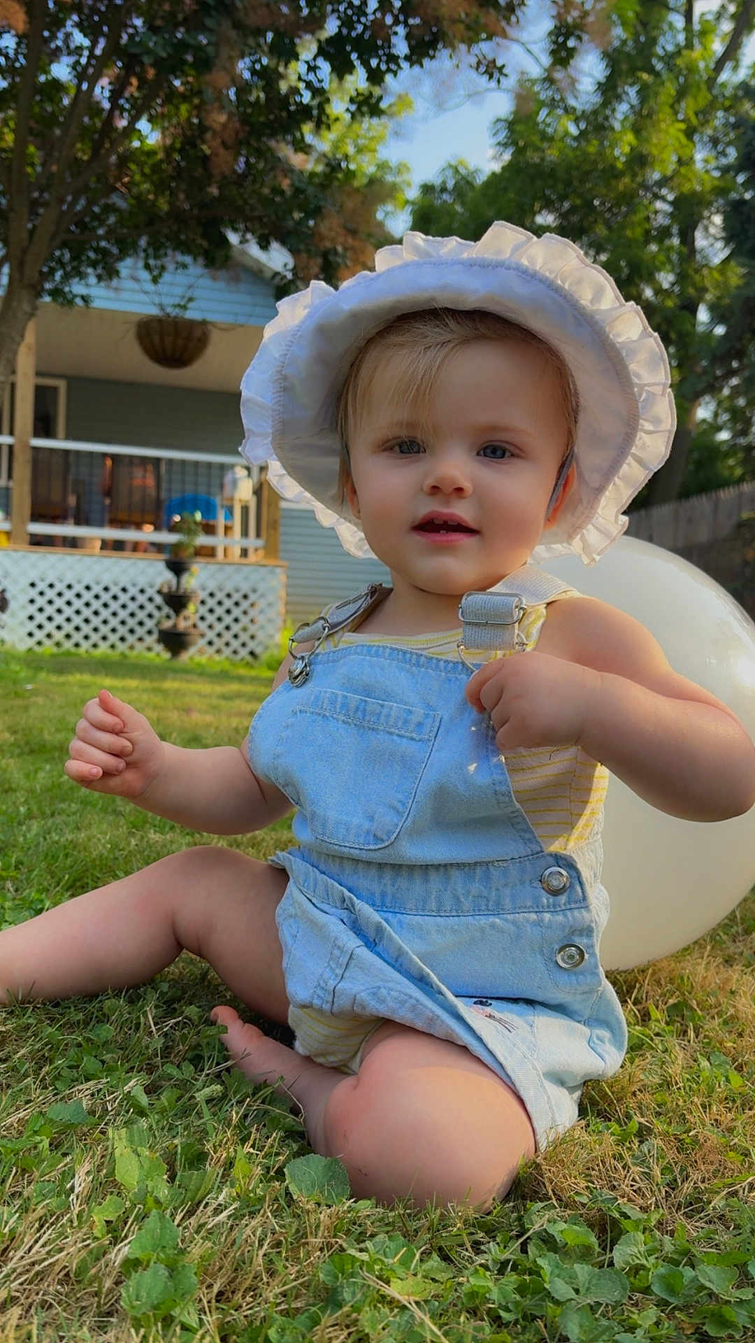 Olivia joined the competition — help win amazing prizes! toddler, child, grass, balloon, hat, denim, overalls, outdoor, sunlight, smiling, baby, nature, greenery, porch, house, summer, cute, sitting, daylight, playful
