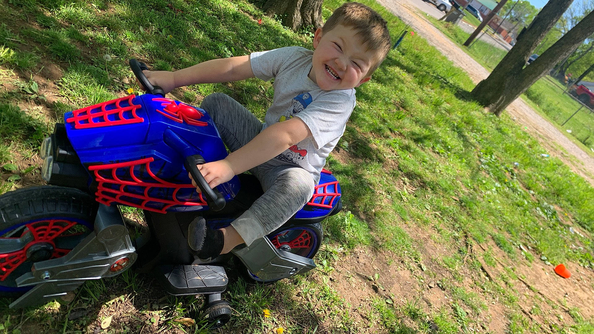 Zaydon is registered to the contest to win money with this photo: automotive_tire, automotive_wheel_system, electric_blue, fun, grass, joy, landscape, lawn, leisure, luggage_and_bags, motor_vehicle, people_in_nature, person, personal_protective_equipment, plant, recreation, smile, tire, toddler, tree