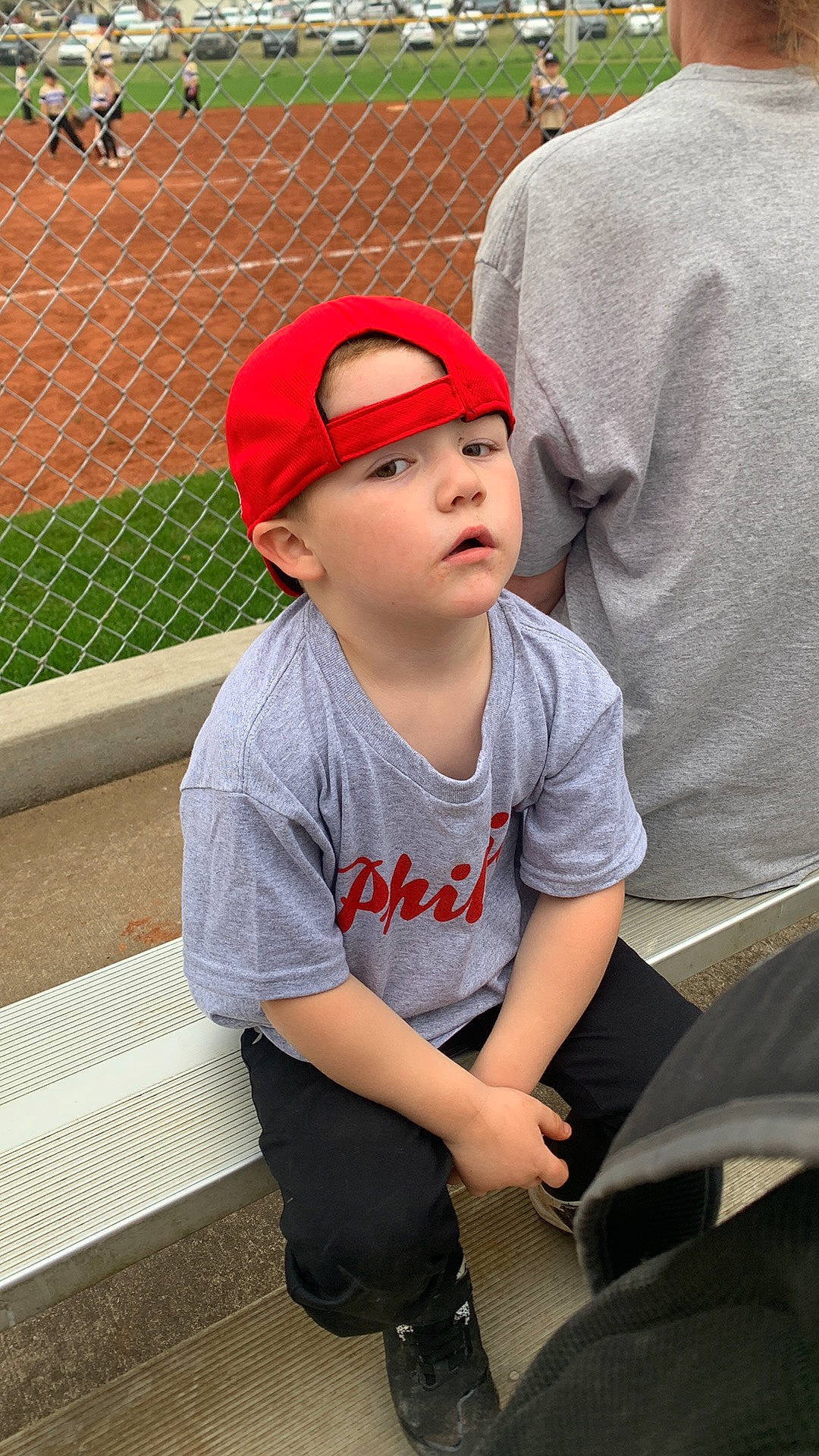 Zaydon is registered to the contest to win money with this photo: baseball_cap, cap, carmine, chain_link_fencing, eyewear, fun, grass, headwear, human_leg, leg, leisure, lip, mesh, person, personal_protective_equipment, shoe, sitting, street_fashion, sunglasses, t_shirt