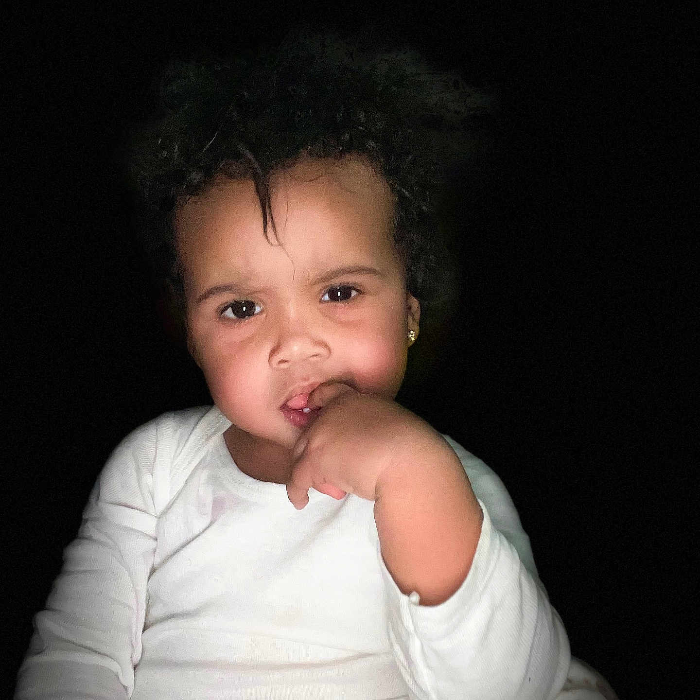 Kaliah joined the competition — help win amazing prizes! casual_clothing, child, curly_hair, cute, cute_expression, dark_background, earrings, expression, face, floral_pants, hand_on_mouth, indoor, person, portrait, sitting, skin_tone, thinking, toddler, white_shirt, young_child