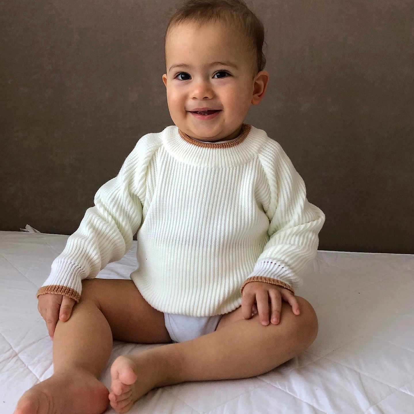 Volodymyr is registered to the contest to win money with this photo: baby, babylaughing, blackboard, clothing, cushion, face, happy, head, homedecor, knitwear, longsleeve, pants, person, photography, portrait, sitting, sleeve, smile, standing, sweater