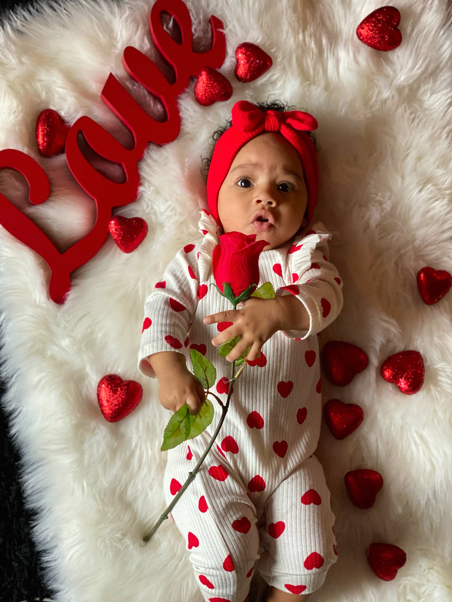 Zariah is registered to the contest to win money with this photo: baby_toddler_clothing, christmas, clothing, dress, face, facial_expression, fur_clothing, gesture, happy, head, headwear, holiday, human_body, outerwear, person, pink, red, santa_claus, sleeve, textile