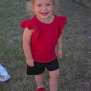 Gracee is registered to the contest to win money with this photo: toddler, child, smiling, red_shirt, black_shorts, red_sneakers, grass, outdoor, happy, bow, face, person, standing, playful, casual_clothing, young_child, cute, daylight, nature, fun