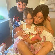 Leslie joined the competition — help win amazing prizes! family, newborn, hospital_room, mother, child, baby, teenager, holding, smiling, people, indoor, bed, postpartum_board, clothing, floor, window, person, footwear, happy, portrait