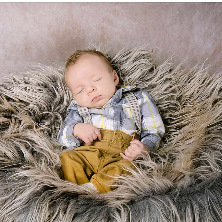 Brax is registered to the contest to win money with this photo: baby, child, closed_eyes, comfortable, cozy, cute, fur_cushion, head, indoor, infant, mustard_pants, peaceful, plaid_shirt, portrait, relaxation, rest, sleeping, small_hands, soft_texture, suspenders