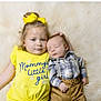 Brax is registered to the contest to win money with this photo: baby, child, toddler, girl, infant, sleeping, yellow_shirt, plaid_shirt, suspenders, fluffy_rug, portrait, siblings, cute, family, indoor, laying_down, holding, smiling, happy, soft_texture