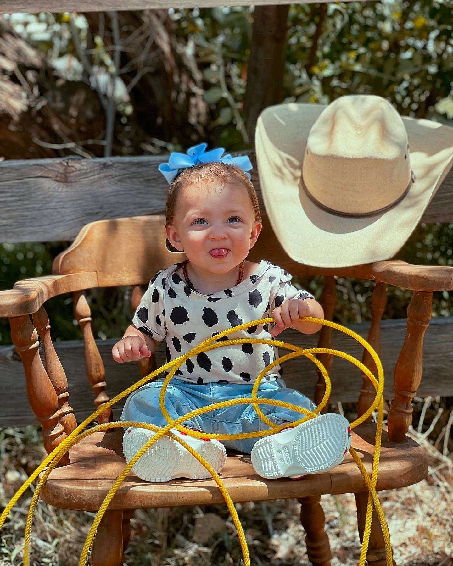 Delta is registered to the contest to win money with this photo: baby, baby_toddler_clothing, chair, child, cowboy_hat, fedora, grass, happy, hat, leisure, outdoor_furniture, people_in_nature, person, recreation, sitting, smile, sun_hat, table, toddler, tree