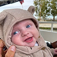 Antonin a rejoint le concours — aidez-le/la à gagner de superbes lots ! baby, child, hoodie, smile, blue_eyes, cute, outdoor, hand, person, face, clothing, button, tree, railing, happy, portrait, infant, warm_clothing, cozy, expression