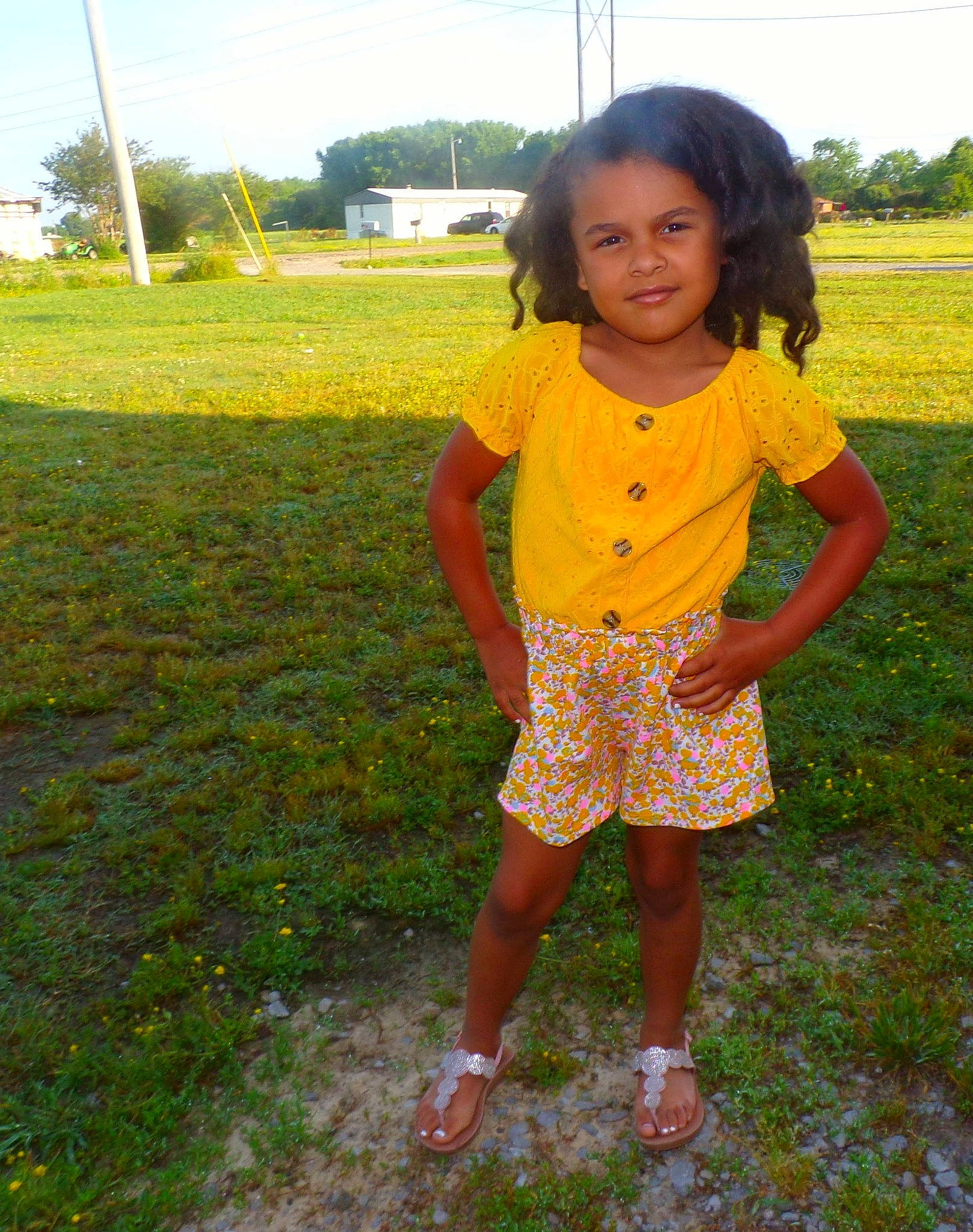 Anastasia is registered to the contest to win money with this photo: baby_toddler_clothing, child, field, footwear, fun, grass, grass_family, grassland, happy, joy, leisure, natural_environment, pattern, people_in_nature, person, plant, sandal, sky, sleeve, soil