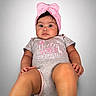 Zara Isabella joined the competition — help win amazing prizes! baby, infant, child, portrait, pink_bow, gray_onesie, sitting, lying_down, face, eyes, feet, legs, smiling, indoor, studio, gray_background, fashion, clothing, adorable, photography