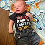 Jacob is registered to the contest to win money with this photo: baby, newborn, infant, clothing, shirt, jeans, blanket, wooden_floor, lying_down, expression, face, hand, cute, child, toddler, casual, indoor, portrait, person, sleepy