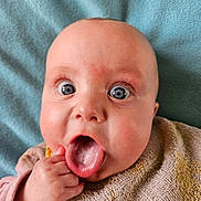 Ashley a rejoint le concours — aidez-le/la à gagner de superbes lots ! baby, tongue, blue_eyes, hand, bib, blanket, expression, closeup, skin, face, infant, cute, child, mouth, tongue_out, soft_texture, pink_clothing, lying_down, cheeks, wide_eyes