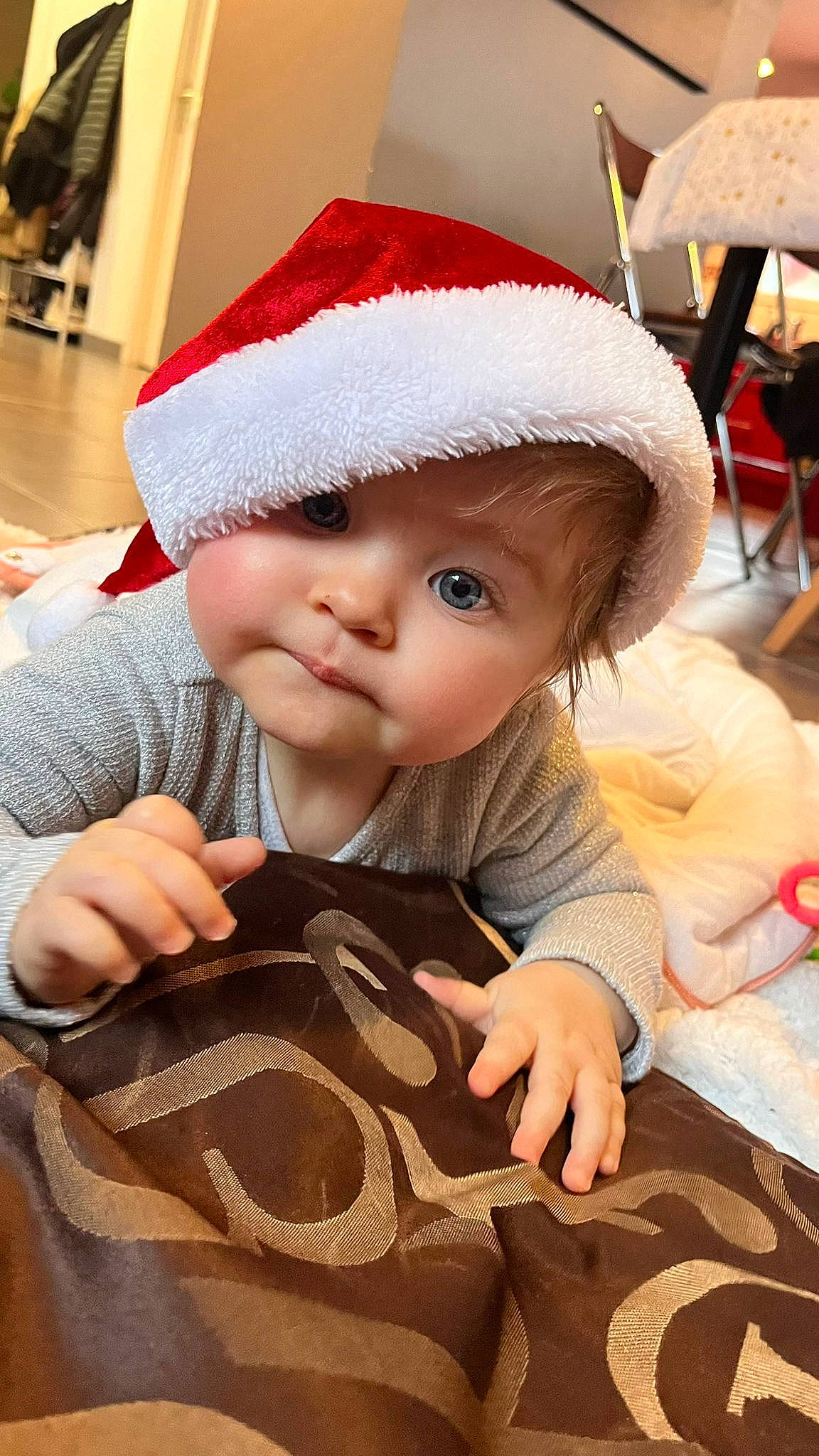 Anaé participe au concours pour gagner de l'argent avec cette photo : baby, baby_toddler_clothing, cap, cheek, child, christmas_eve, doll, eye, flooring, fur, headwear, holiday, mammal, person, sitting, skin, textile, toddler, toy, tree