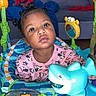 baby, background_child, child, colorful, couch, curious_expression, fish_toy, hair_buns, jumper, living_room, minnie_mouse, pajamas, plastic, play_center, play_mat, shark_toy, sofa_cushion, toddler, toy, wide_eyes